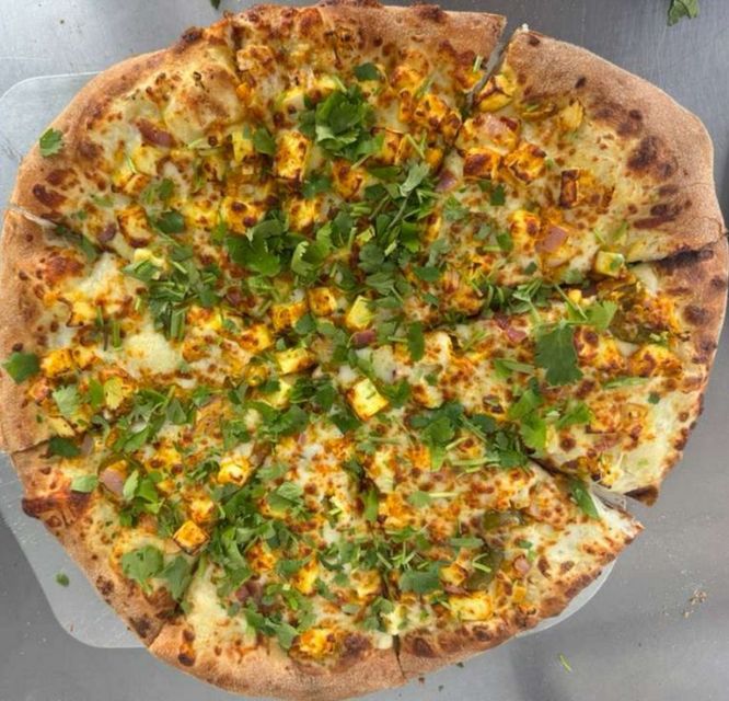 Cheese and herb pizza on a gray plate, with a lightly charred crust and golden toppings