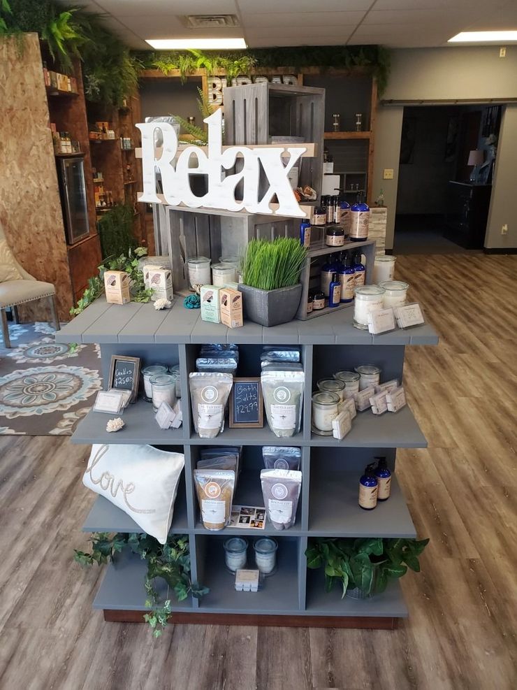 Retail display with potted plants, candles, and product packages in a store interior