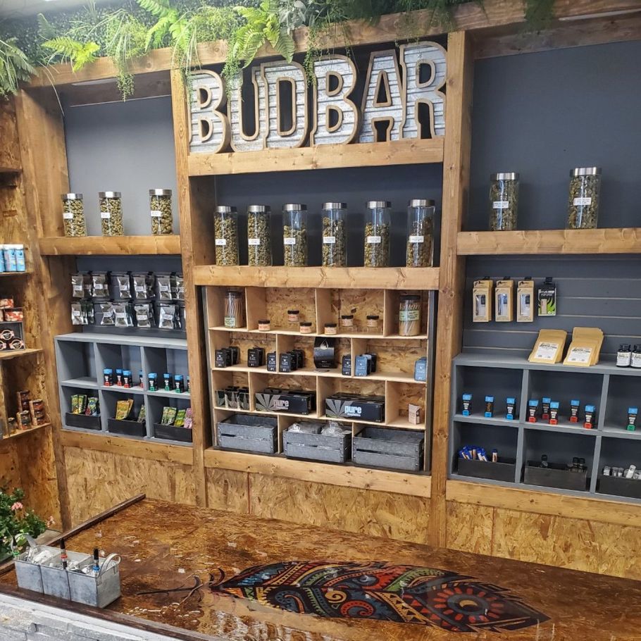 BOBAR shop display with wooden shelves, jars, and product packages on a rustic wall