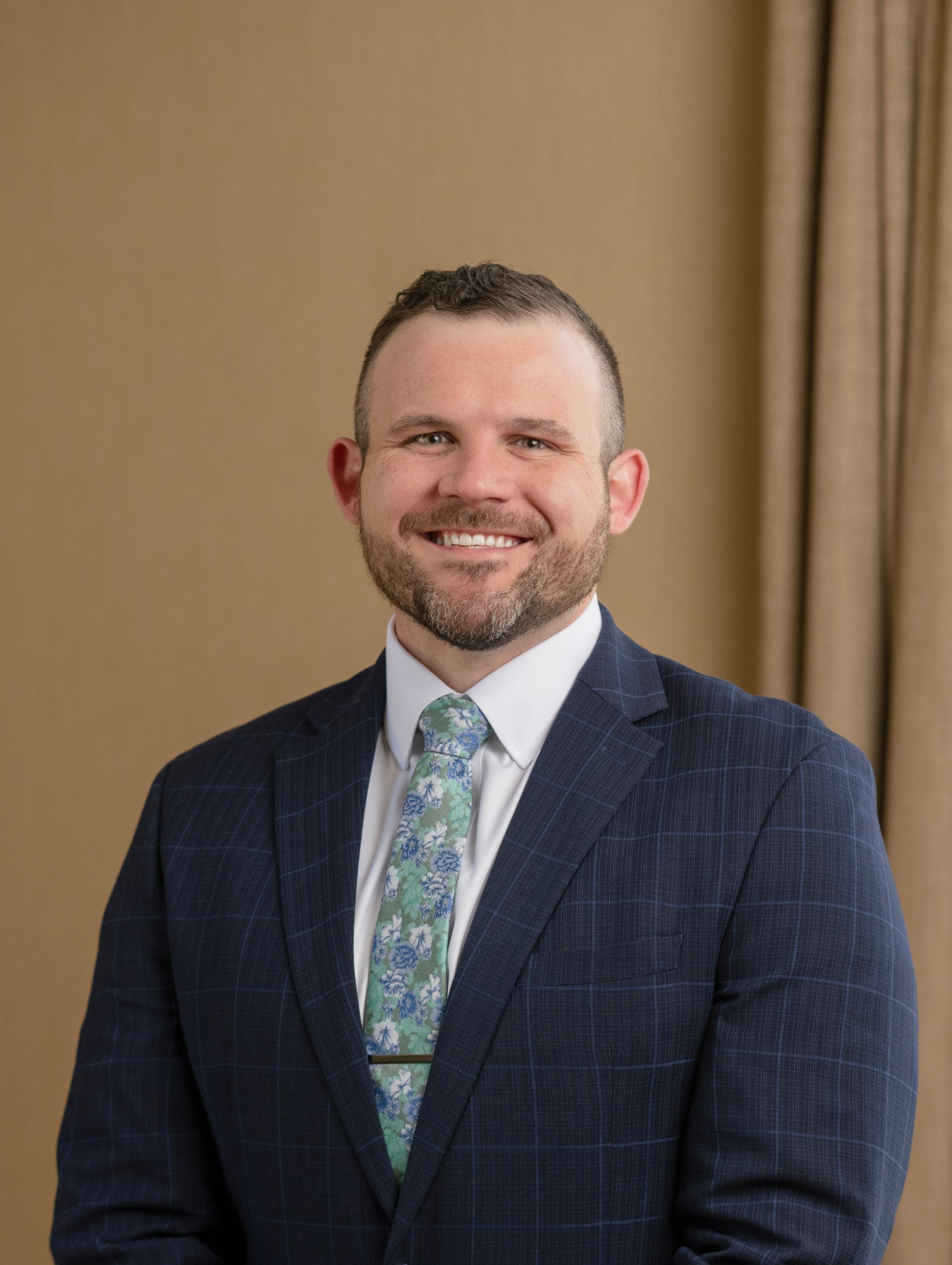 A man in a suit and tie is smiling for the camera.