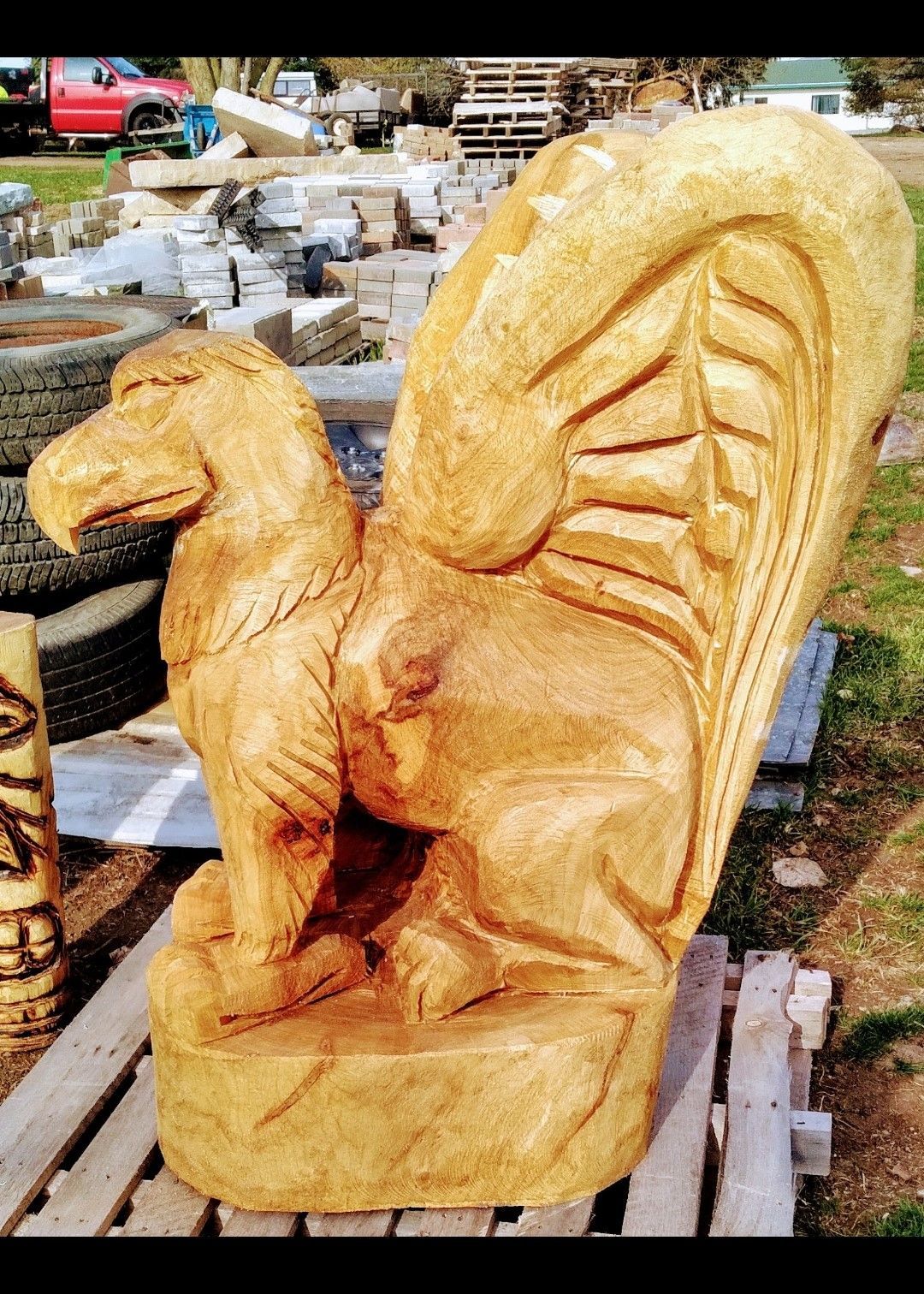 Wooden squirrel carving on a pallet outdoors, showing detailed fur and tail
