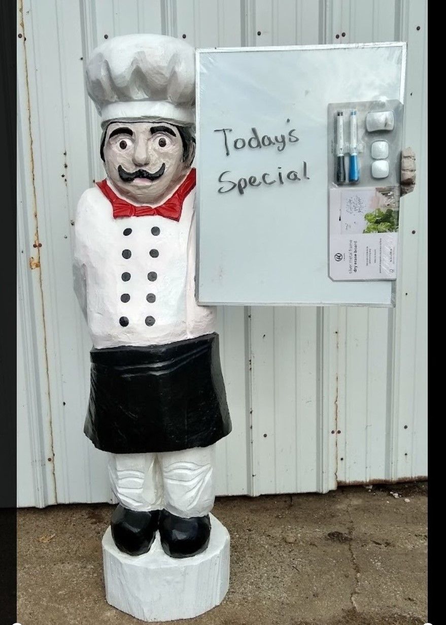 Chef statue beside a “Today’s Special” sign and menu board outside a restaurant