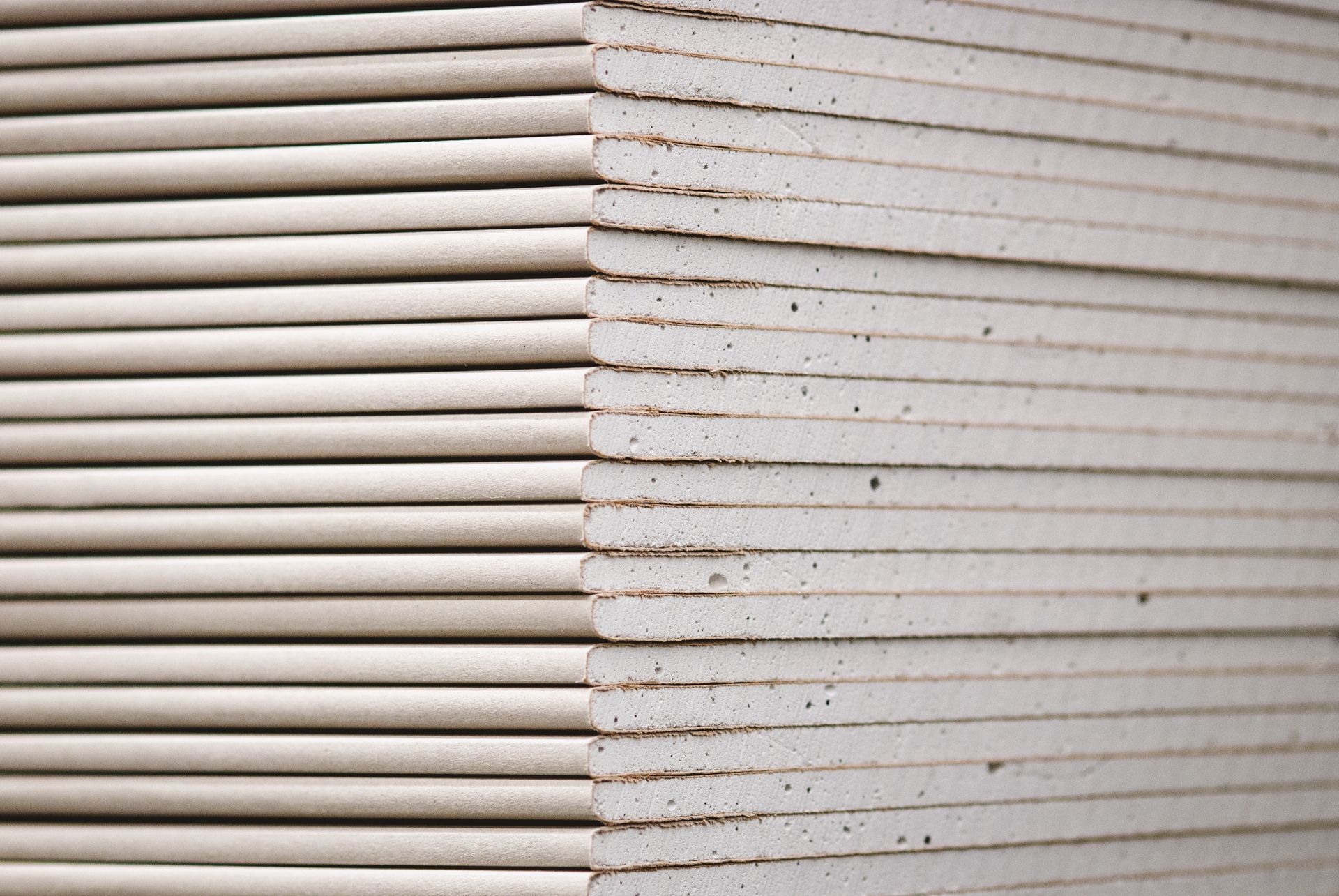 Gyprock standard panels, wallboards, and plasterboard stacked in a hardware store close-up. Gyprock standard panels, wallboards, and plasterboard stacked in a hardware store close-up.