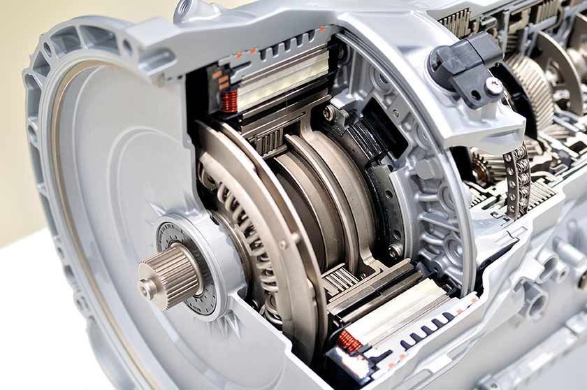 Open mechanical transmission with exposed gears, shafts, and silver housing on a white background