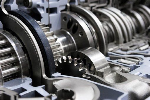 Close-up of shiny metal gears and machine parts in an industrial mechanical assembly