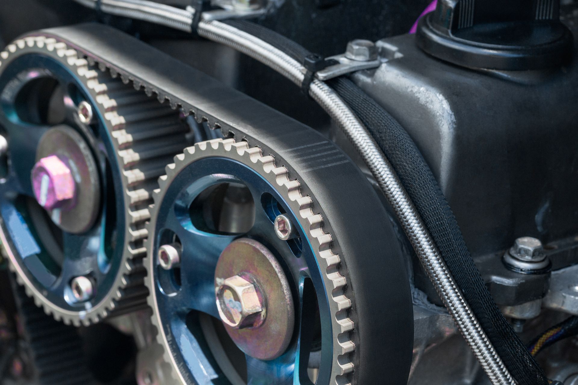 Close-up of engine timing gears and belt under a black cover