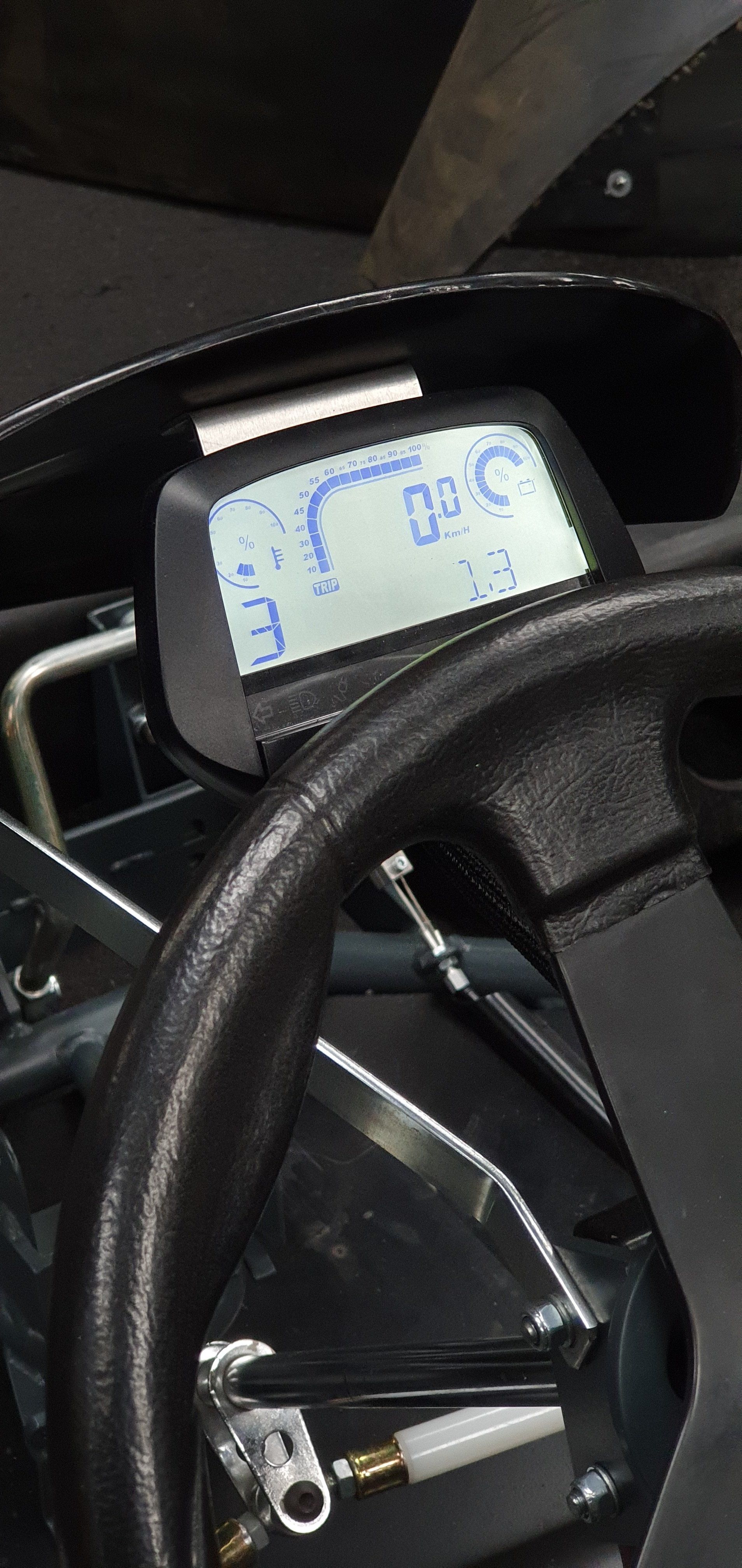 A close up of a steering wheel with a digital display on it.