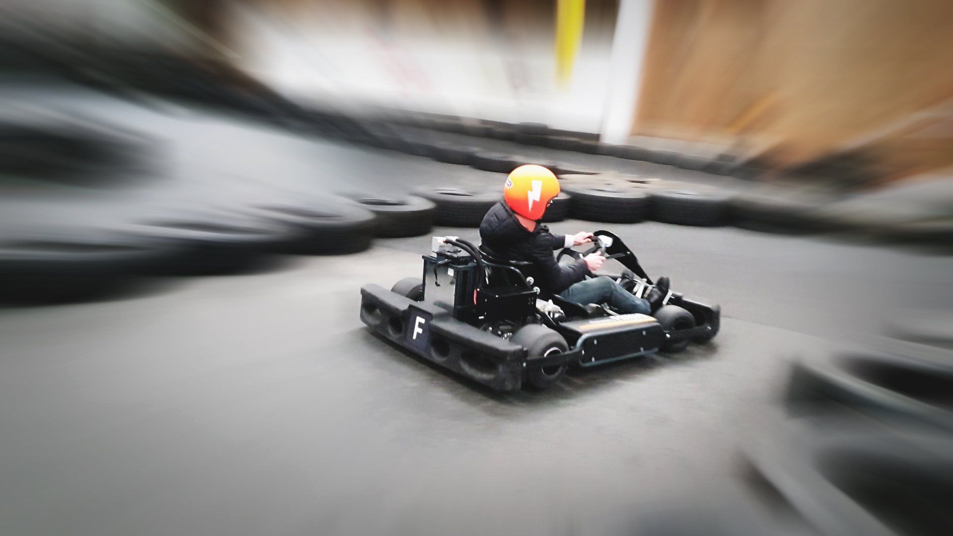 A person is riding a go kart on a track.