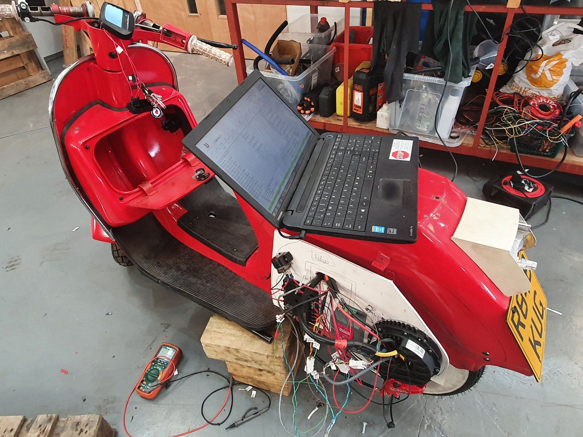 A red scooter with a laptop on top of it