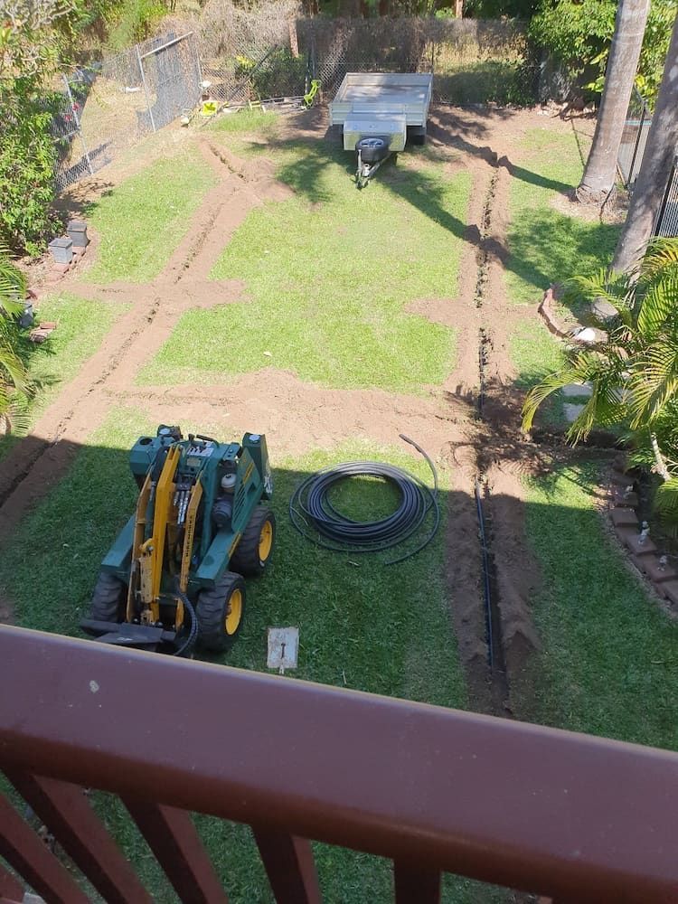 A Green And Yellow Tractor Is Parked In A Grassy Field — Irrig8 in Palmerston, NT