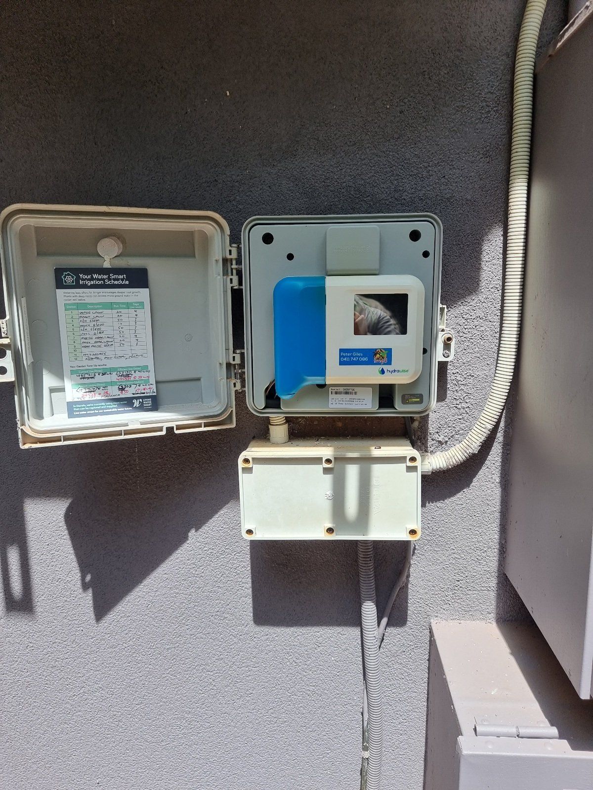 A Telephone Box Is Sitting On A Wall Next To A Telephone Cord — Irrig8 in Palmerston, NT