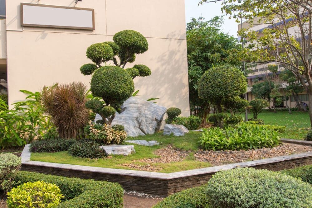 A Garden With Trees And Bushes In Front Of A Building — Irrig8 in Palmerston, NT