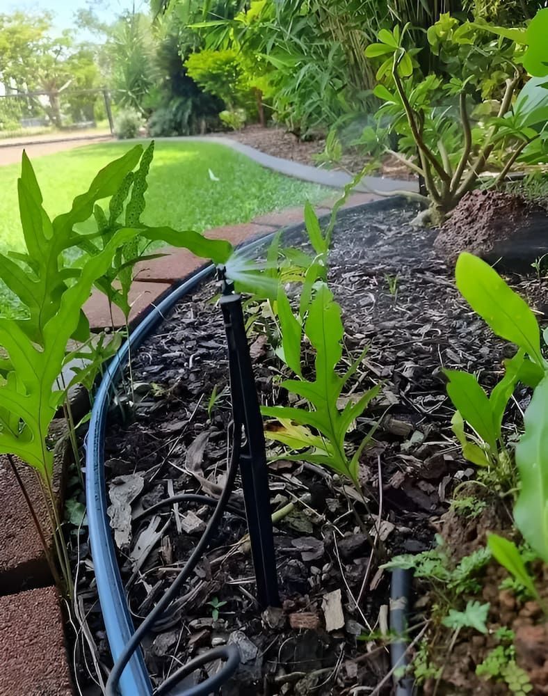 A Hose Is Being Used To Water Plants In A Garden — Irrig8 in Palmerston, NT