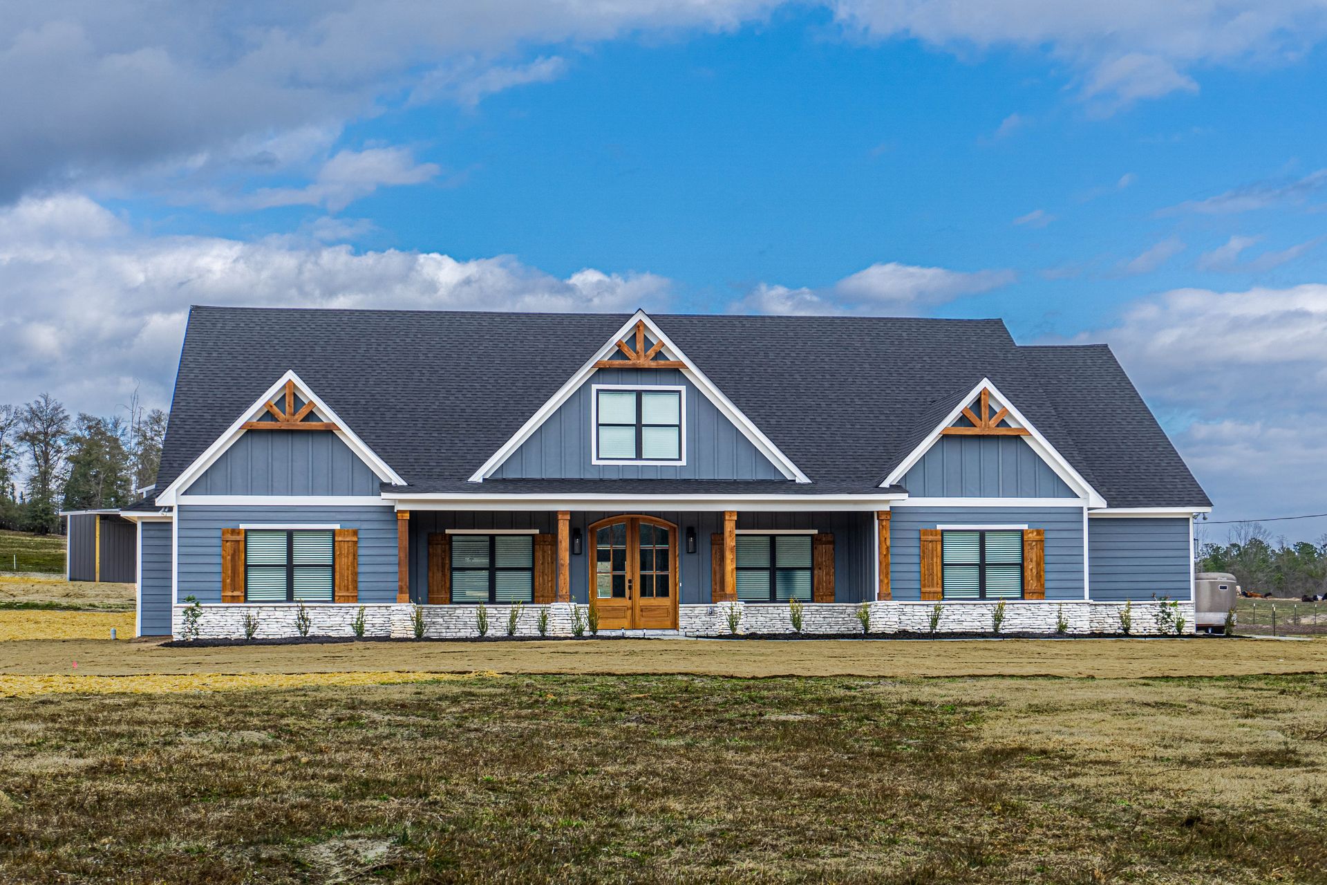 A new home is sitting on top of a lush green field.