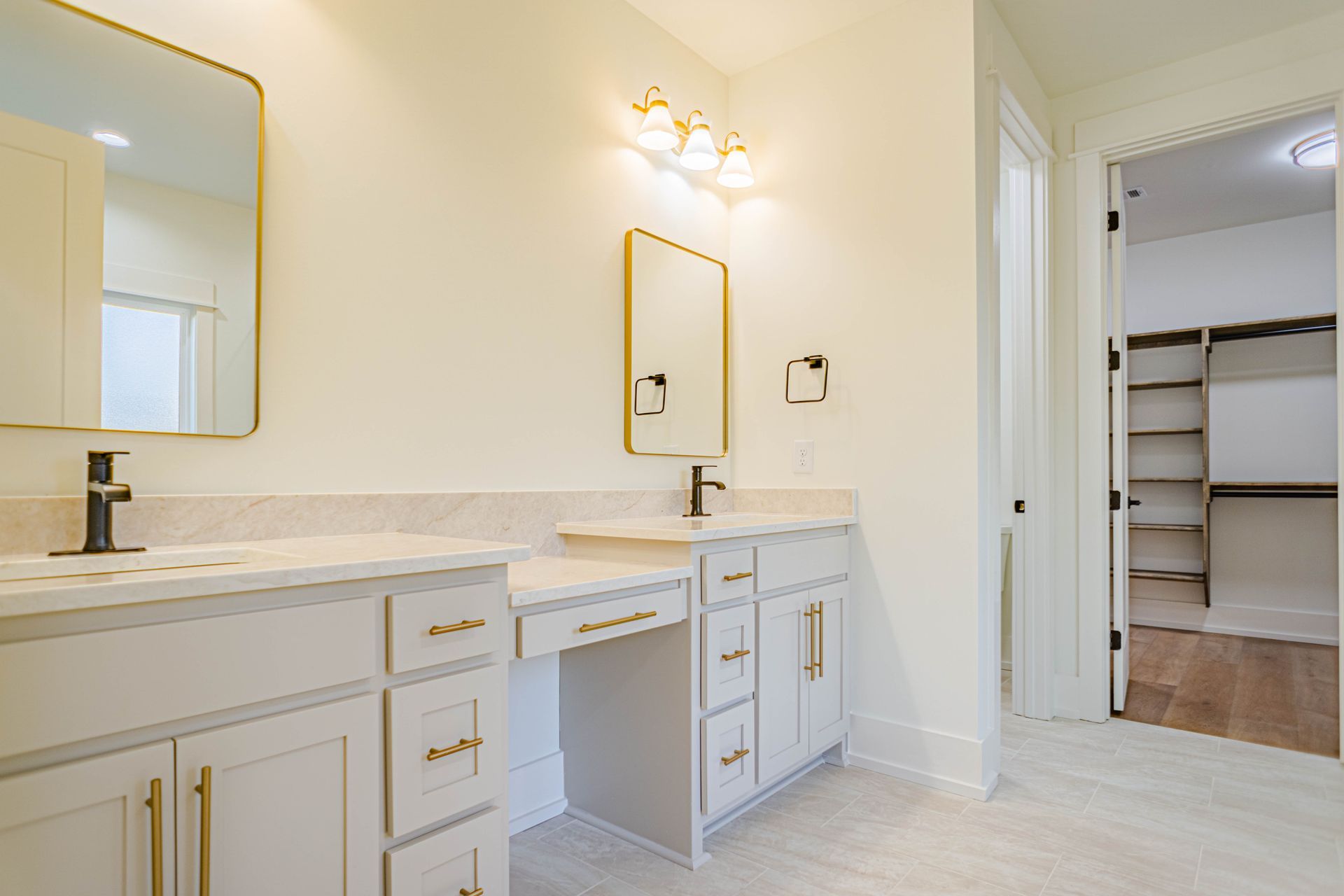 A bathroom with two sinks , a mirror and a walk in closet.
