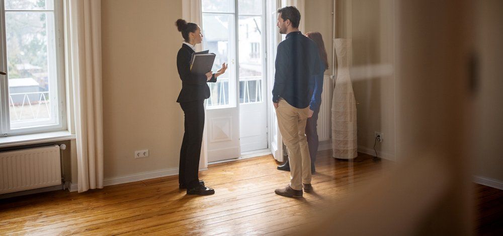Real Estate Agent Talking With Young Couple — Austin, TX — Property Management Of Texas Real Estate Agent Talking With Young Couple — Austin, TX — Property Management Of Texas