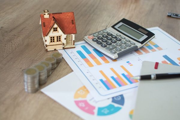 Calculator With Small House Model — Austin, TX — Property Management Of Texas Calculator With Small House Model — Austin, TX — Property Management Of Texas