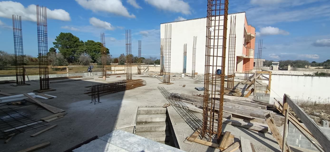 Un cantiere con un grande edificio bianco sullo sfondo