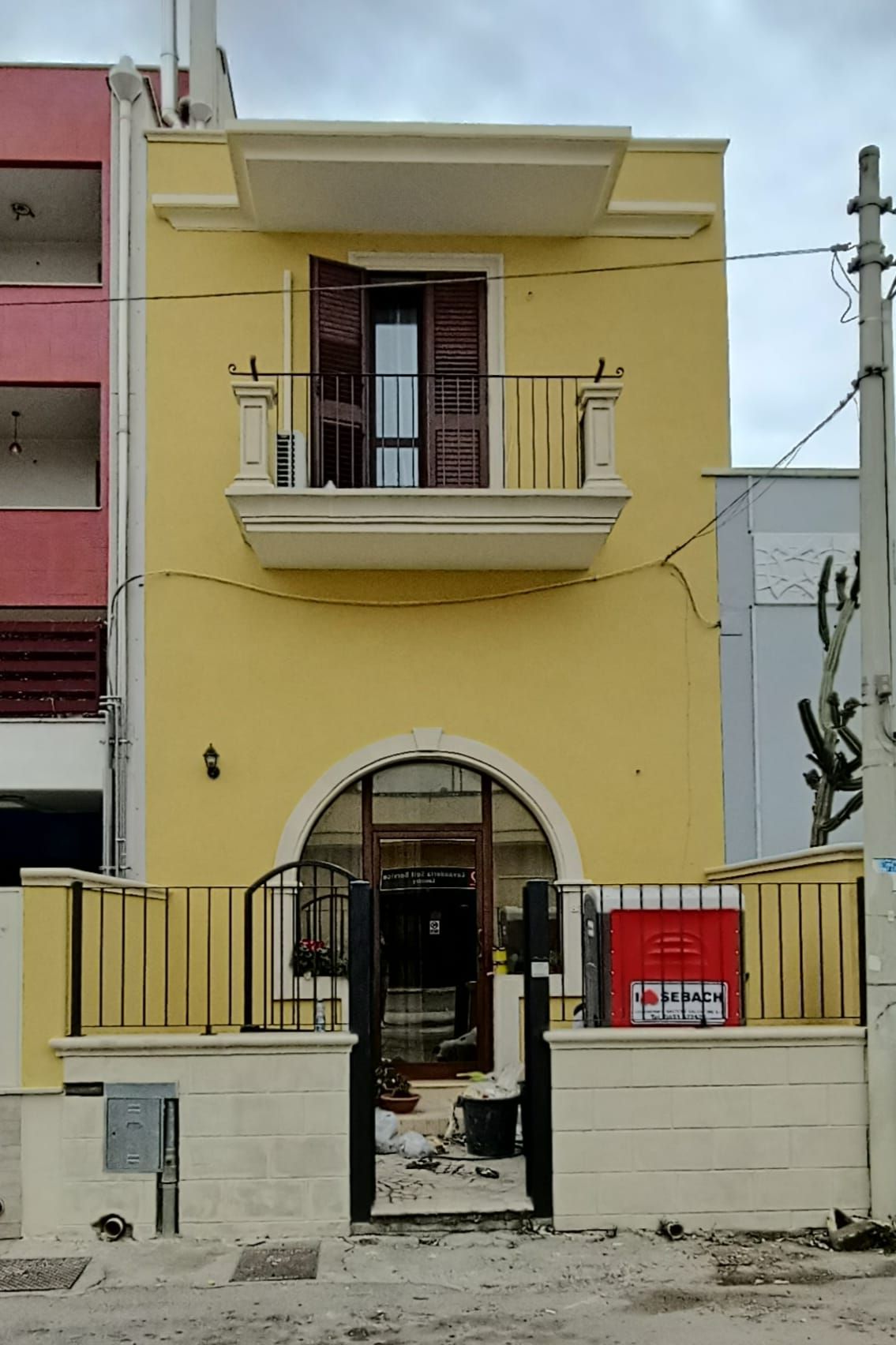 Un edificio giallo con un balcone e una recinzione
