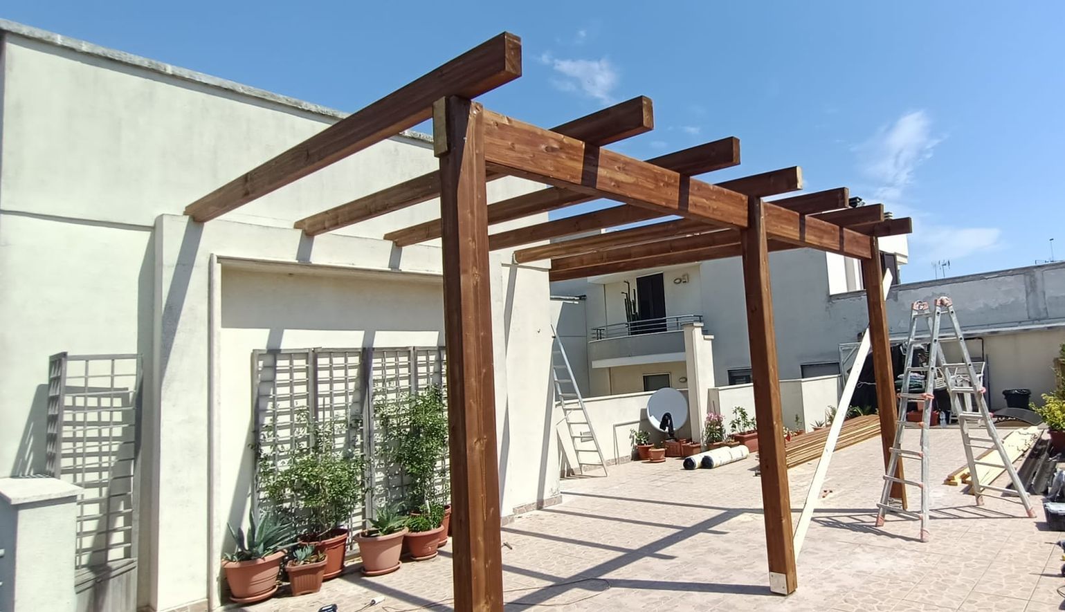Sul tetto di un edificio viene costruito un pergolato in legno.