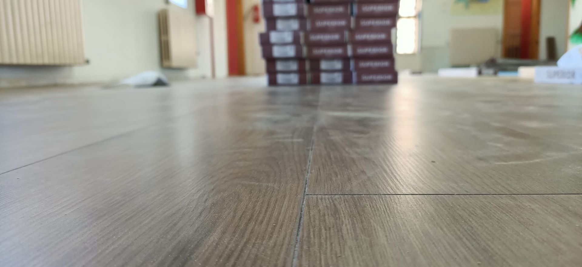 Una pila di scatole appoggiata su un pavimento di legno.