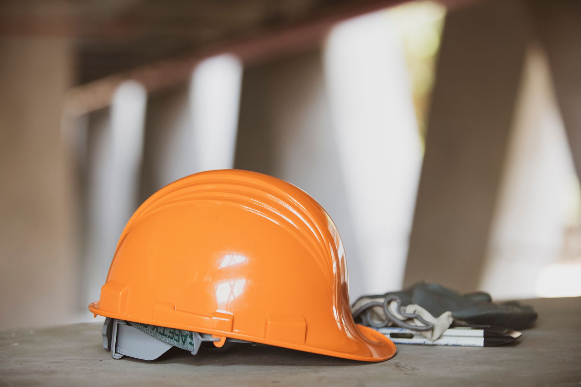 Un casco arancione è appoggiato su un tavolo di legno.