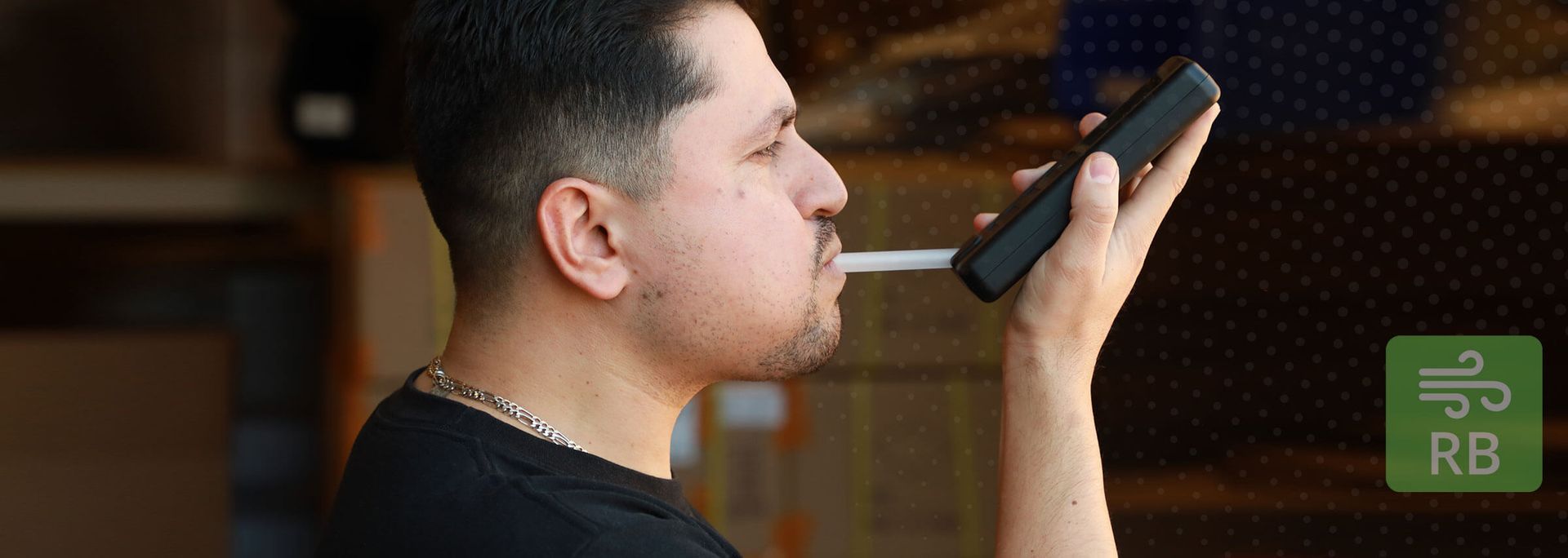 Person speaking into a handheld microphone indoors, side view with a blurred background