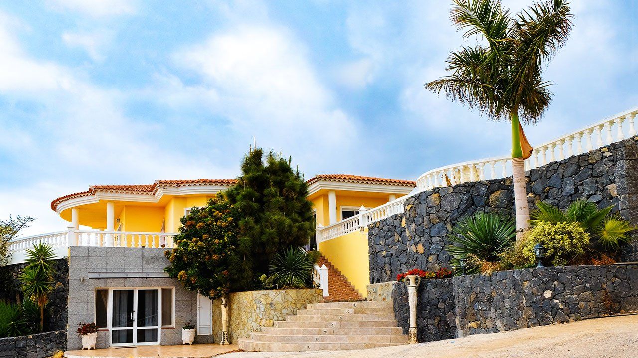 Beautiful yellow and white tenerife house and palm tree