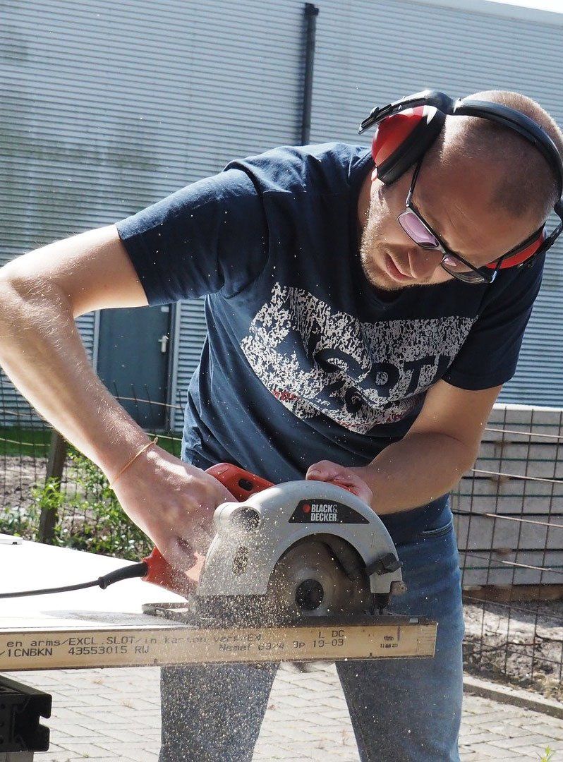 man in protective ear muffs using a grinder