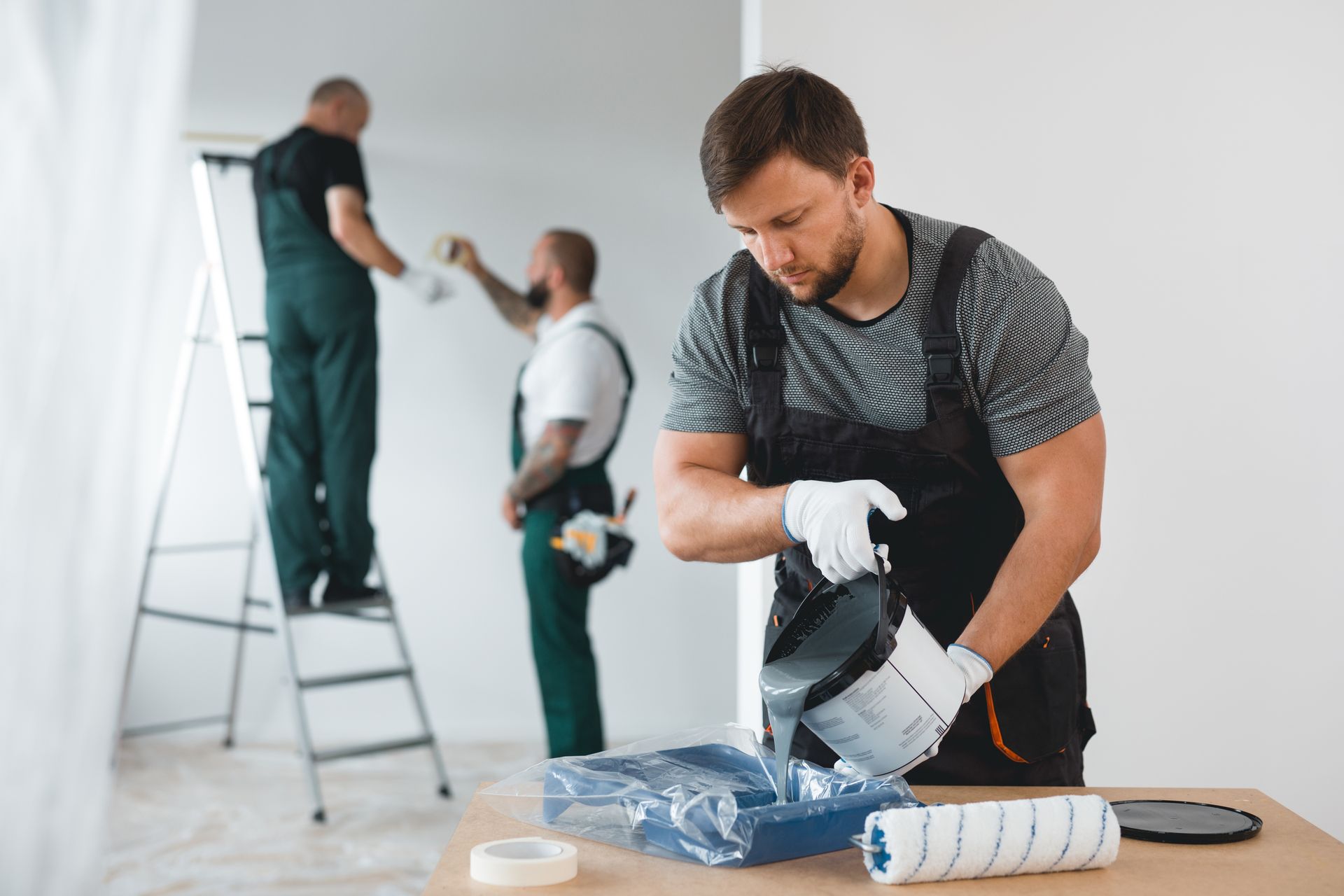An efficient company crew is painting the white walls of a new build home. An efficient company crew is painting the white walls of a new build home.