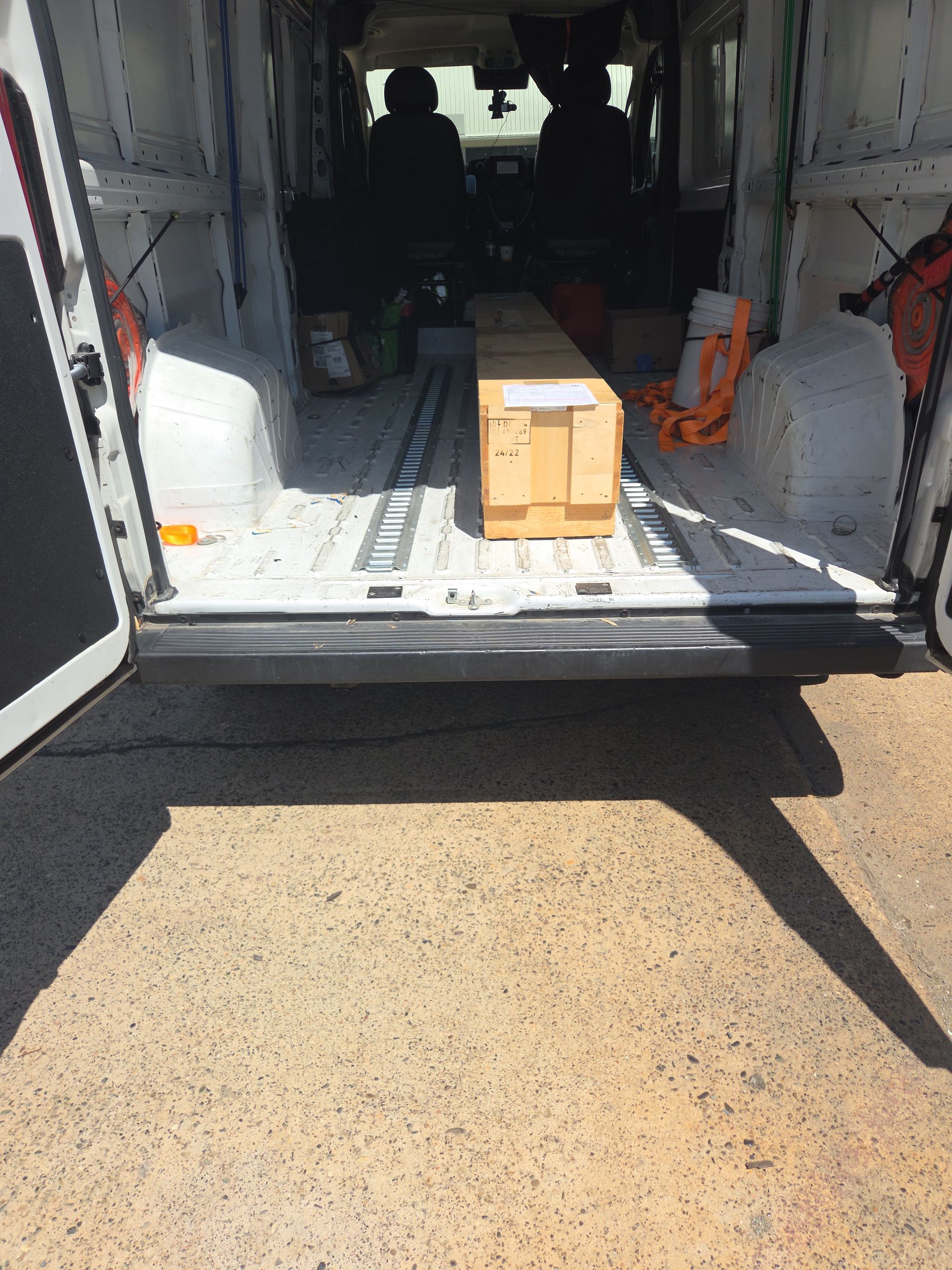 Open van interior with a small cardboard box on the floor near the rear door ramp.