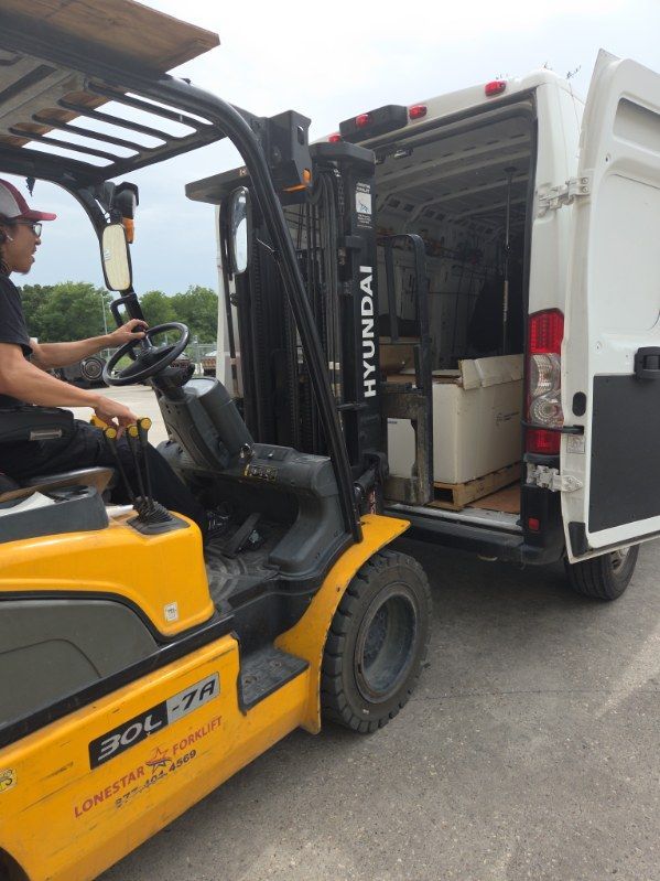 Forklift loading white cargo truck with stacked boxes in warehouse yard