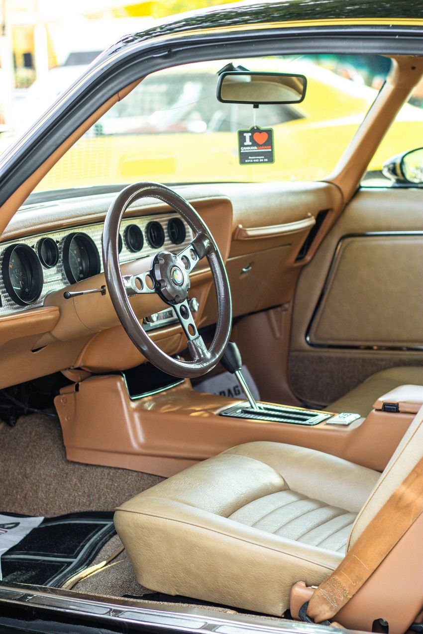 Tan leather car interior with wood steering wheel and center console