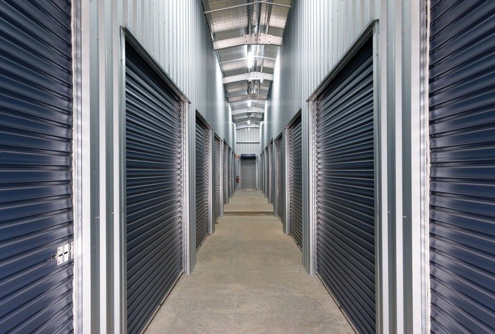 Indoor hallway with closed gray metal storage unit doors and a polished floor