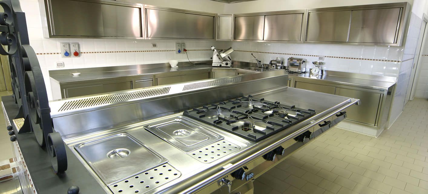una cucina con elettrodomestici in acciaio inossidabile compreso un forno con piano cottura