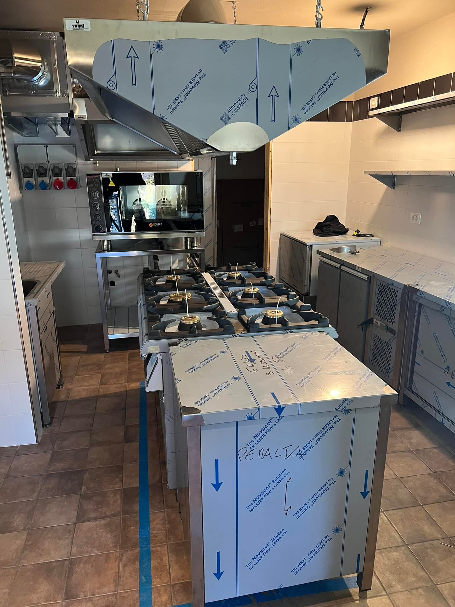 una cucina con elettrodomestici in acciaio inossidabile compreso un forno con piano cottura