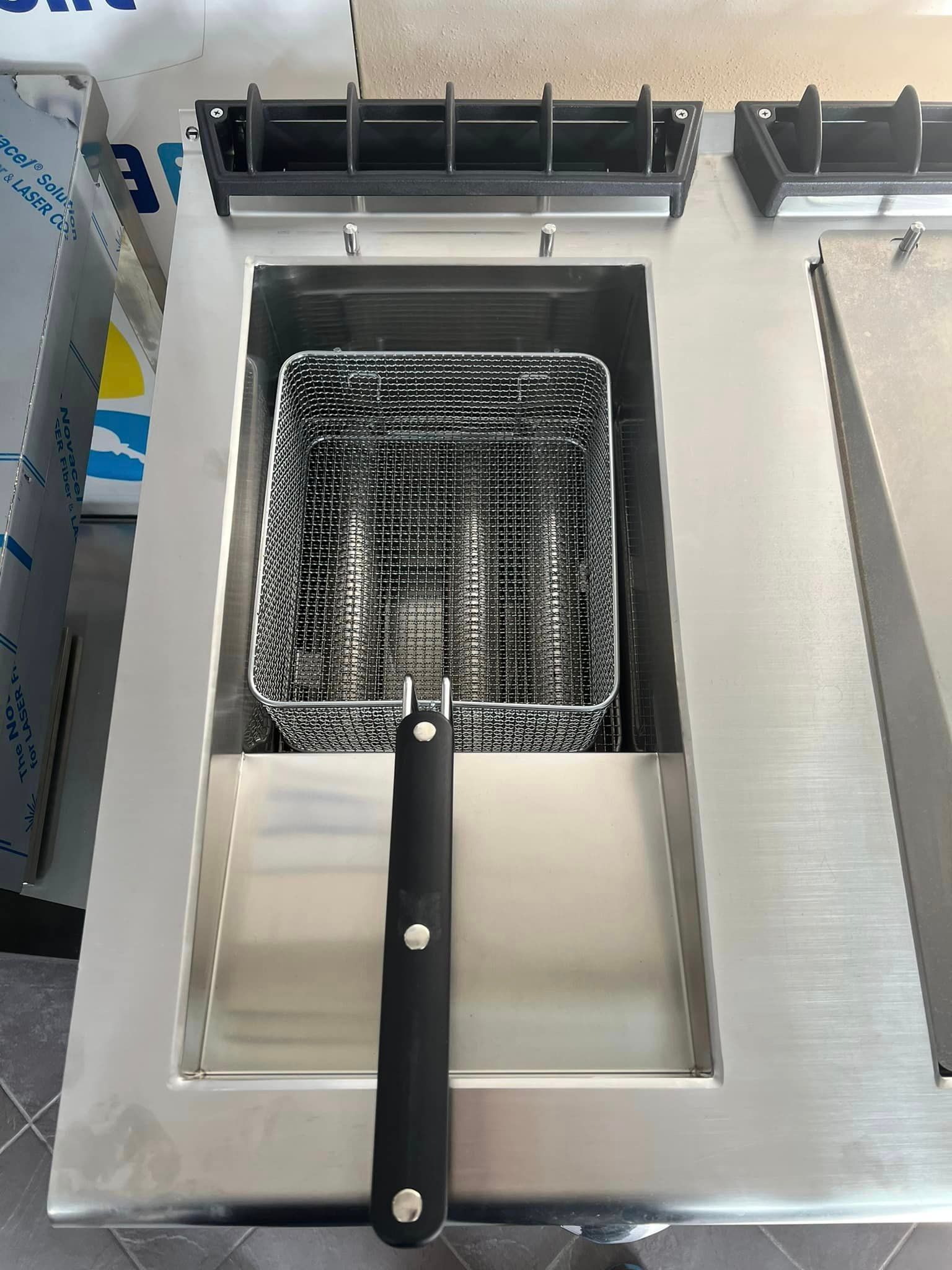 una friggitrice in acciaio inossidabile con manico nero