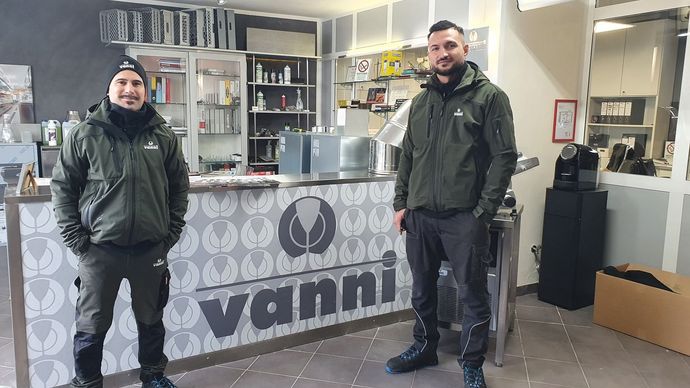 due uomini in piedi davanti ad un bancone vanni