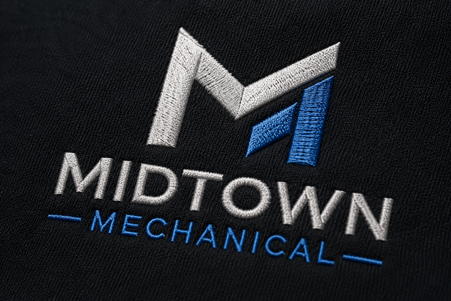 Midtown Mechanical logo in white and blue on a dark textured background