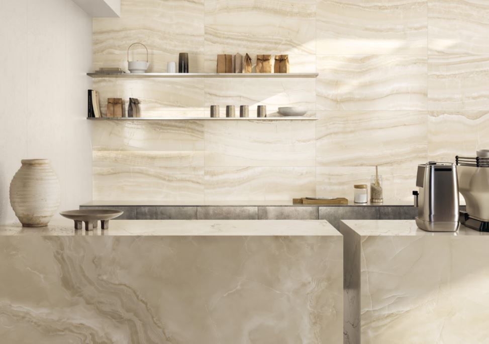 Una cucina minimalista con ripiani e paraschizzi in onice color crema, mensole a vista e macchina del caffè.