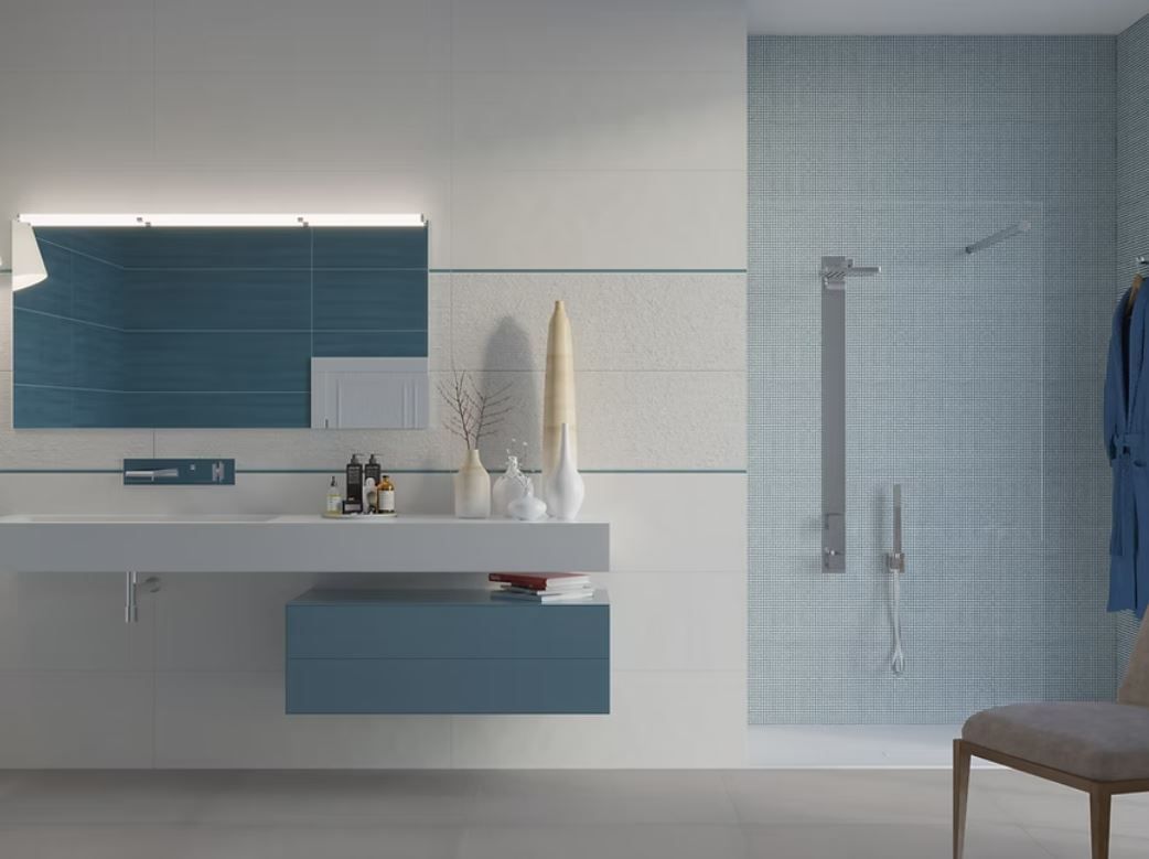Un bagno moderno con mobile lavabo bianco e cassetti blu, specchio blu abbinato e box doccia piastrellato di blu.