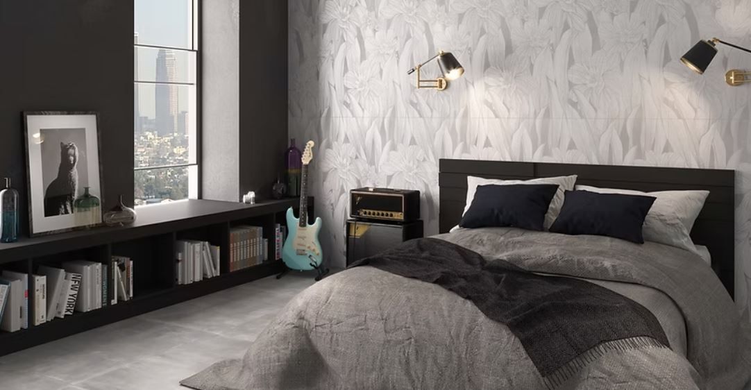 Camera da letto moderna con parete grigia texturizzata, letto scuro, chitarra e mensole a vista vicino a una finestra con vista sulla città.