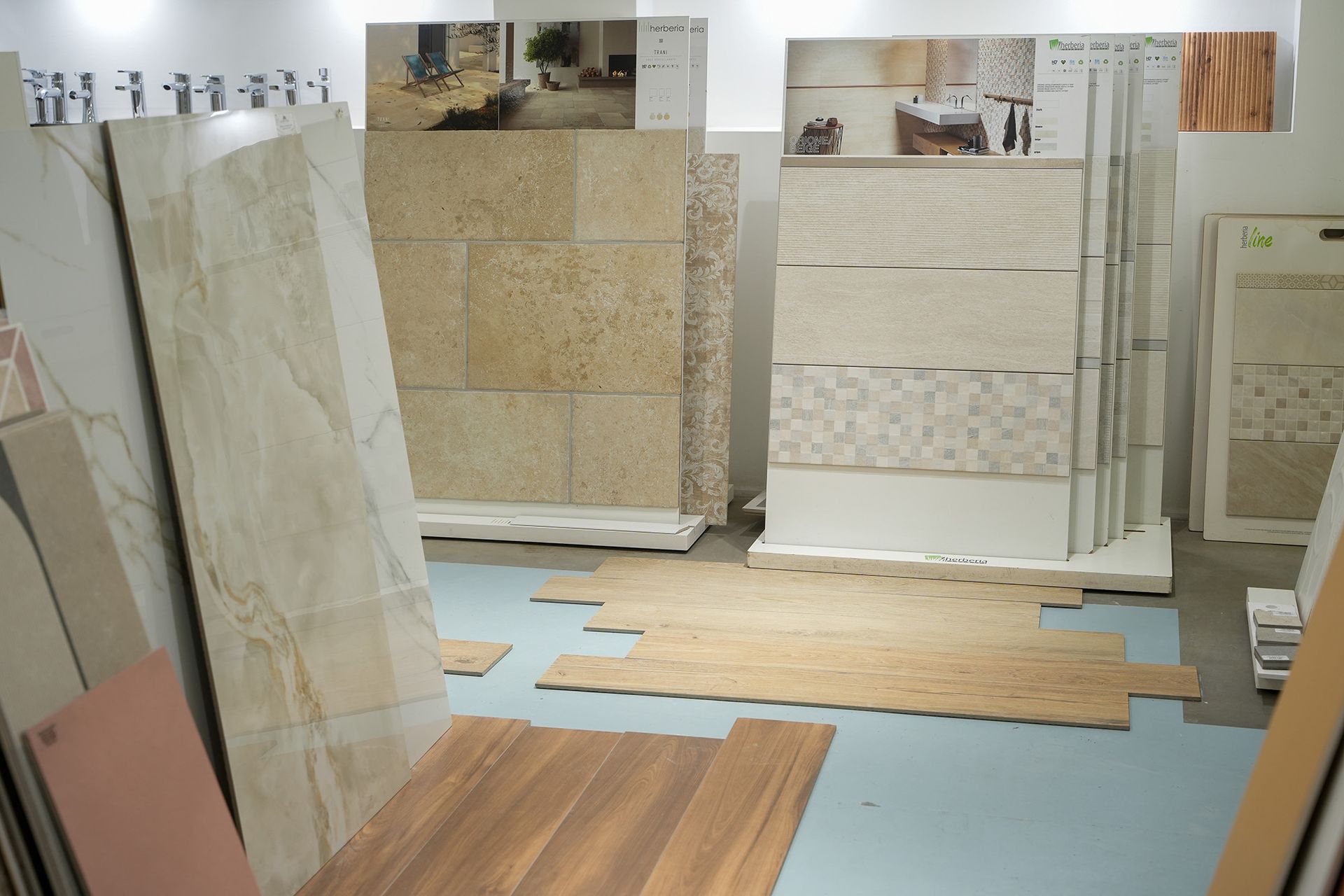 Uno showroom che espone vari stili di piastrelle da rivestimento di grandi dimensioni e campioni di pavimenti effetto legno.