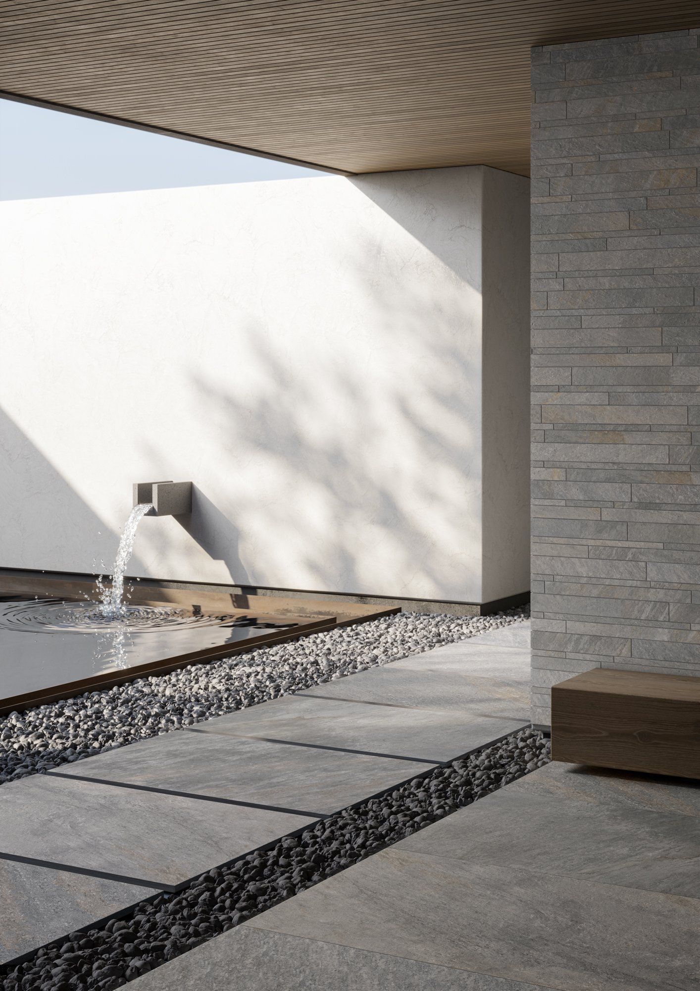 Un patio moderno e minimalista caratterizzato da un muro in pietra, una fontana, un soffitto con finitura a rilievo e un pavimento piastrellato in grigio con inserti di ghiaia.