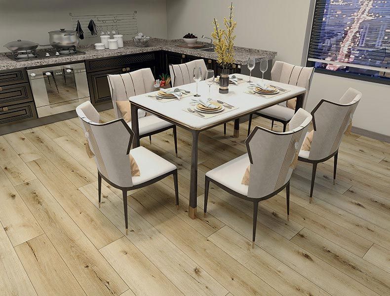 Un set da pranzo composto da un tavolo rettangolare bianco e sei sedie imbottite color avorio chiaro, in una cucina con pavimento in legno chiaro.