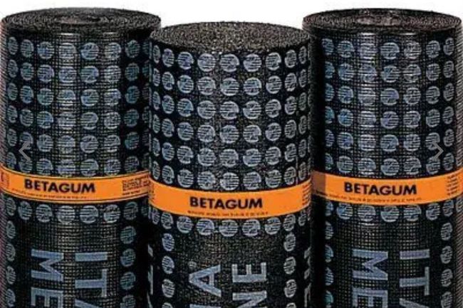 Tre rotoli di membrana impermeabile nera e zigrinata con etichette arancioni del marchio 
