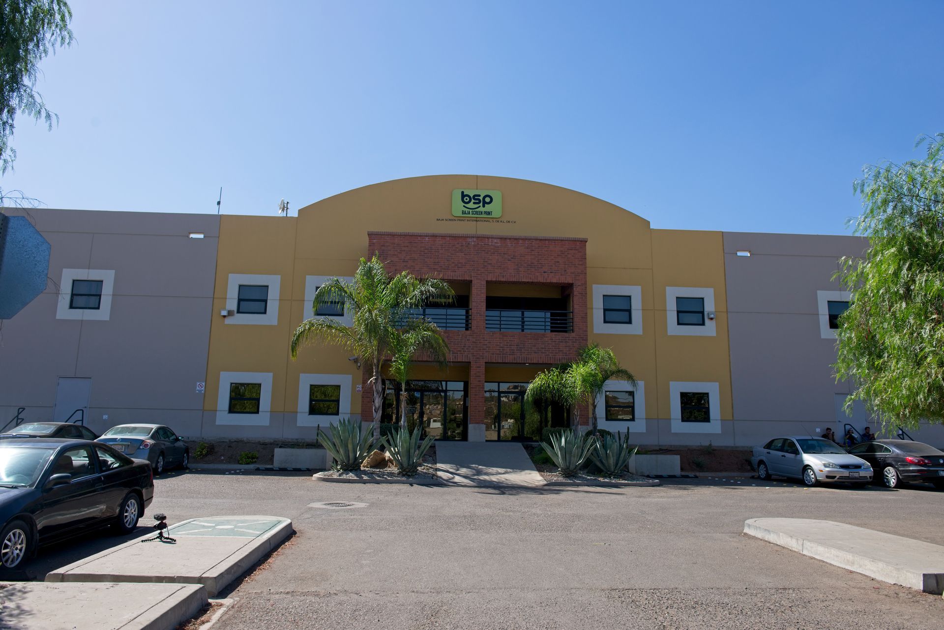 Exterior of a Baja Fresh restaurant building with parked cars in front
