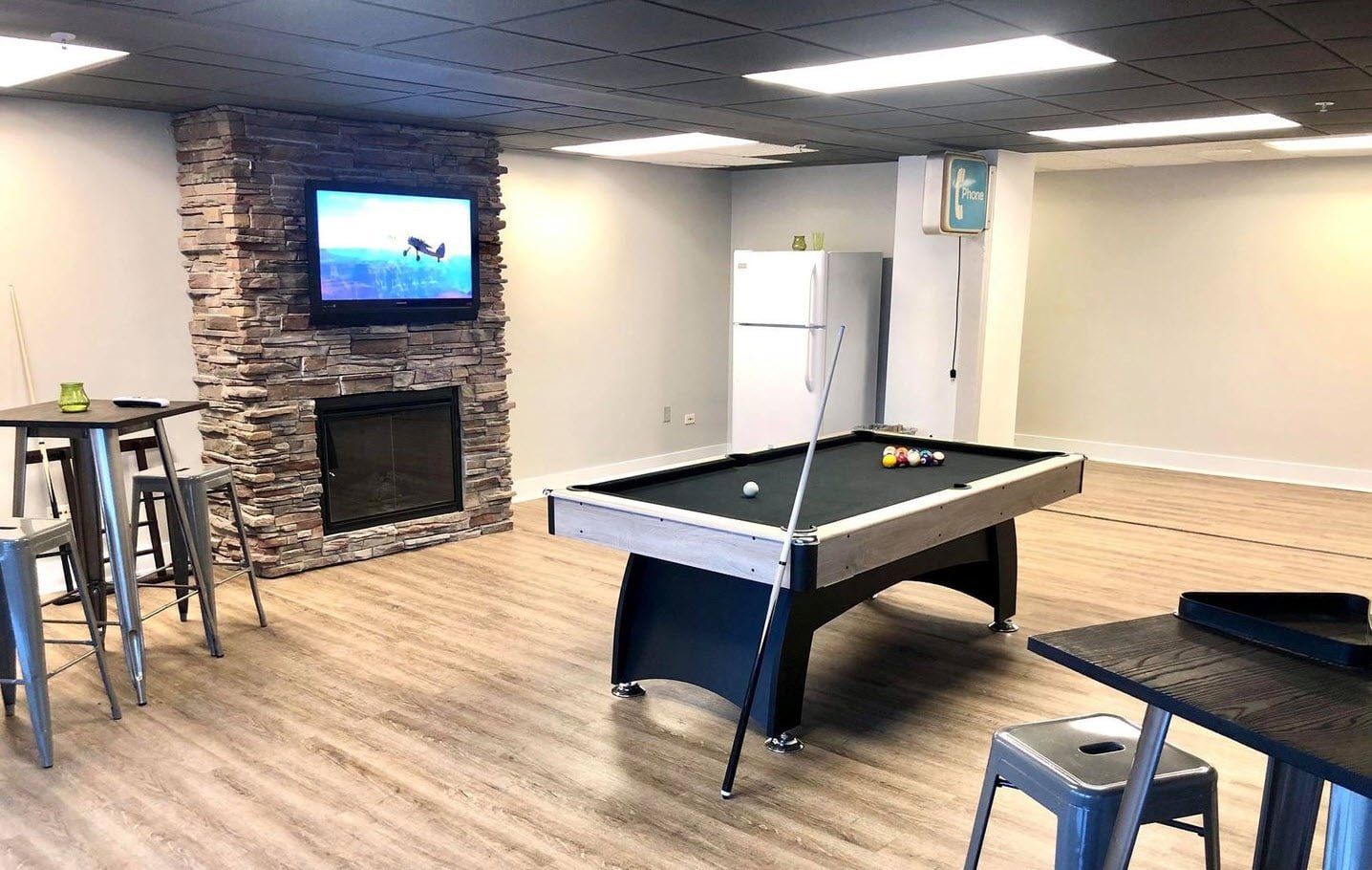 Downtown Des Moines, IA Apartments- The Village at Grays Lake- Billiards Table with Seating Area and Fireplace