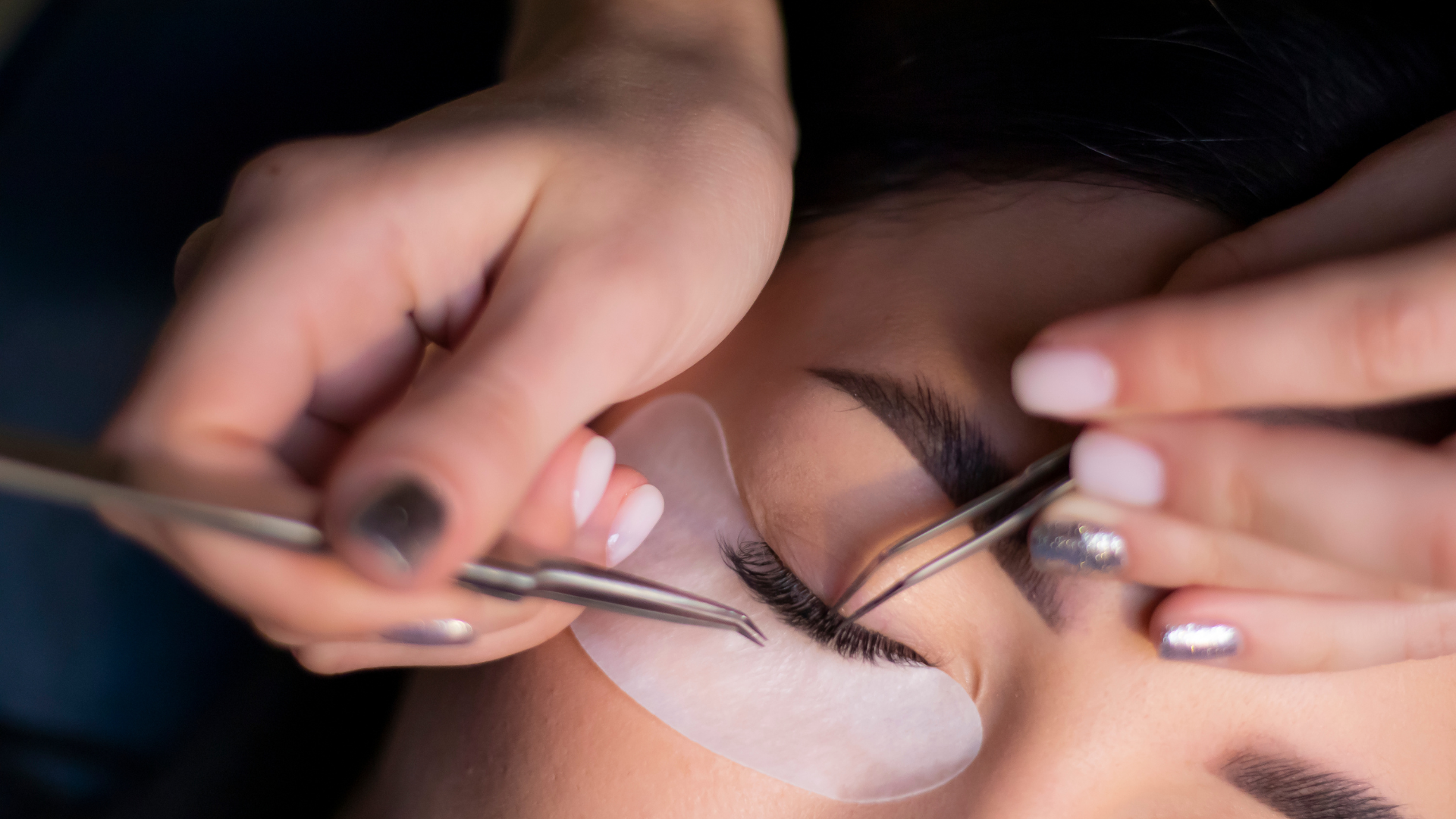 A woman is getting her eyelashes done at a beauty salon.
