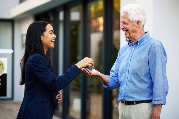 A woman is handing a man a set of keys